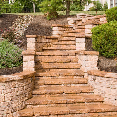 Photo of a mid-sized traditional partial sun hillside concrete paver formal garden in Philadelphia for spring.