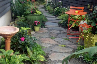 Photo of a small eclectic shade side yard stone landscaping in Seattle.