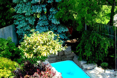 Immagine di un piccolo giardino stile rurale esposto in pieno sole dietro casa in estate con fontane e pavimentazioni in pietra naturale