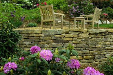 Imagen de jardín clásico de tamaño medio en patio trasero con jardín francés, muro de contención, exposición parcial al sol y mantillo