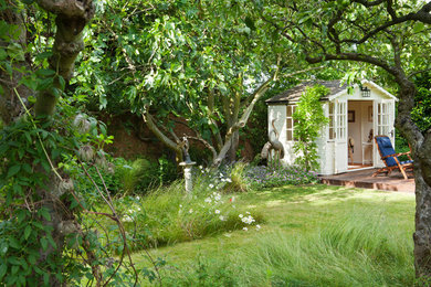 Idées déco pour un grand jardin à la française arrière classique l'été avec une exposition ensoleillée et une terrasse en bois.