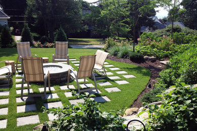 Foto de jardín clásico de tamaño medio en verano en patio trasero con brasero, exposición parcial al sol y adoquines de piedra natural