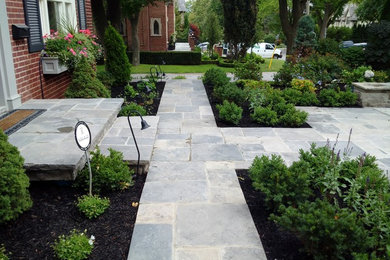 Inspiration for a mid-sized traditional partial sun backyard stone landscaping in Orange County.