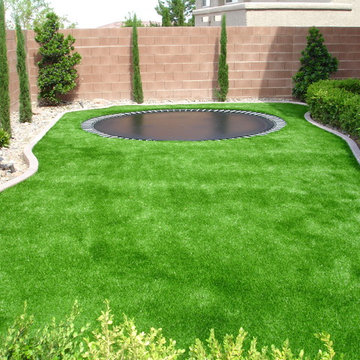 Trampoline surrounded by sythetic turf.