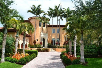Inspiration for a large tropical front yard stone landscaping in Miami.