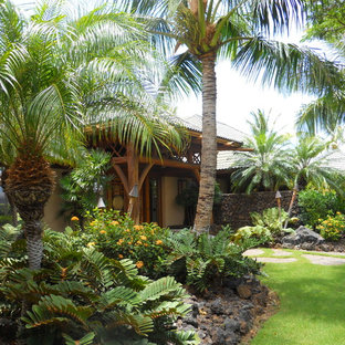 Inspiration for a mid-sized tropical partial sun front yard stone landscaping in Hawaii.