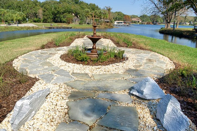 This is an example of a huge traditional full sun backyard stone landscaping in Orlando for fall.