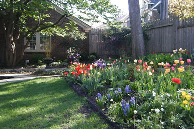 Foto de jardín clásico de tamaño medio en primavera en patio trasero con exposición parcial al sol y adoquines de piedra natural