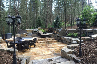 Photo of a huge rustic hillside stone retaining wall landscape in Calgary.