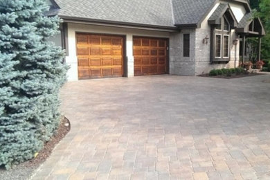 Photo of a large traditional full sun front yard brick driveway in Milwaukee.