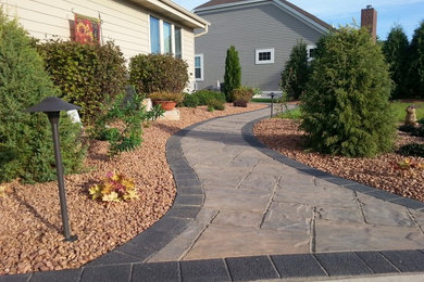 Photo of a mid-sized traditional full sun backyard stone garden path in Milwaukee.
