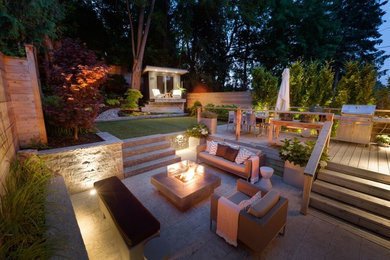 This is an example of a small contemporary backyard stone landscaping in Toronto with a fire pit.