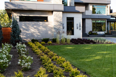 Photo of a large contemporary front yard flower bed in Edmonton.