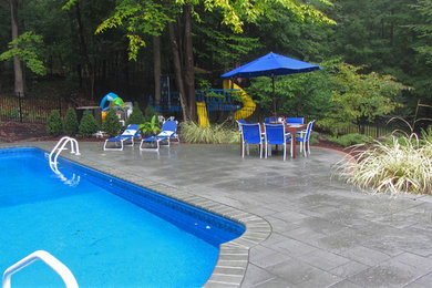 Photo of a partial sun backyard concrete paver retaining wall landscape in New York for summer.