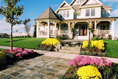 Large traditional front formal full sun garden in Minneapolis with natural stone paving.