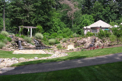 Ejemplo de jardín contemporáneo de tamaño medio en patio trasero con exposición total al sol, adoquines de piedra natural y estanque