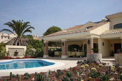 Diseño de jardín de secano mediterráneo de tamaño medio en patio trasero con fuente, exposición total al sol y adoquines de piedra natural