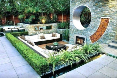This is an example of a mid-sized modern full sun backyard concrete paver formal garden in Other with a fire pit for spring.
