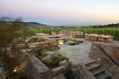 Imagen de jardín clásico grande en patio trasero con fuente, exposición total al sol y adoquines de piedra natural