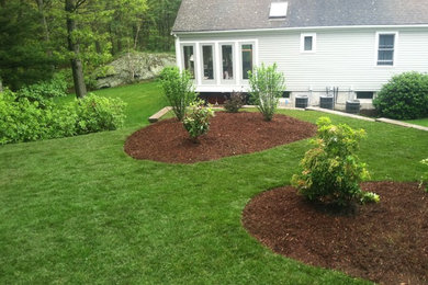 Inspiration for a mid-sized traditional full sun backyard mulch retaining wall landscape in Boston for spring.