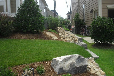 Design ideas for a mid-sized traditional partial sun front yard stone landscaping in Raleigh.