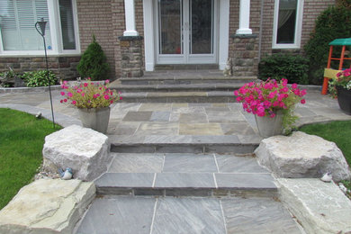 Photo of a mid-sized full sun front yard stone garden path in Toronto.