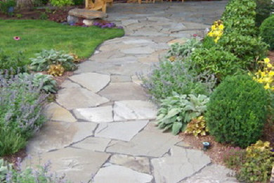 Photo of a large traditional full sun front yard concrete paver landscaping in New York.