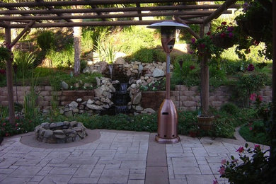 Large full sun garden in Los Angeles with natural stone paving.