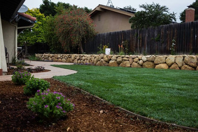 Inspiration for a mid-sized traditional full sun backyard concrete paver retaining wall landscape in San Luis Obispo.