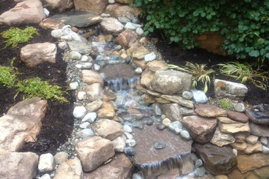 Design ideas for a mid-sized rustic partial sun backyard mulch pond in Other.