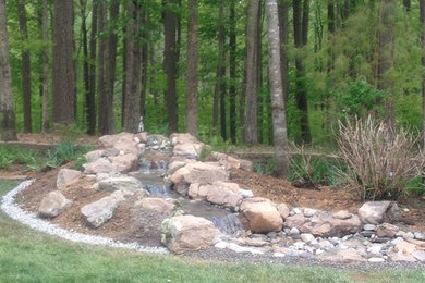 Design ideas for a mid-sized rustic partial sun backyard water fountain landscape in Other.