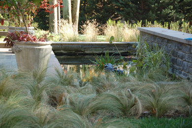 Стильный дизайн: огромный регулярный сад на боковом дворе в стиле неоклассика (современная классика) с полуденной тенью и покрытием из каменной брусчатки - последний тренд