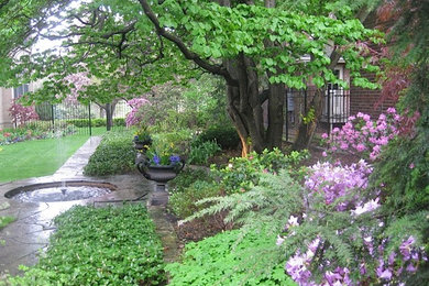 Imagen de camino de jardín tradicional de tamaño medio en primavera en patio trasero con exposición parcial al sol y adoquines de piedra natural