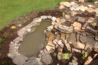 Photo of a large transitional backyard mulch pond in Chicago.