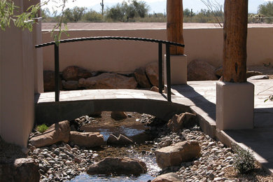 This is an example of a large partial sun backyard stone water fountain landscape in Phoenix for summer.