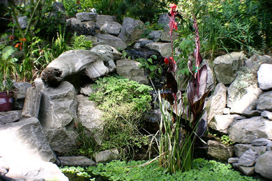 This is an example of a large traditional backyard stone water fountain landscape in Portland.