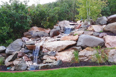 Inspiration for a large traditional partial sun hillside stone water fountain landscape in Salt Lake City for summer.