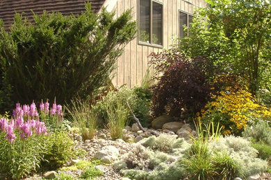 Modelo de jardín rural de tamaño medio en verano en patio delantero con fuente y exposición total al sol