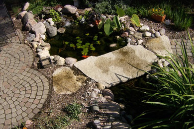 Photo of a mid-sized eclectic full sun backyard concrete paver water fountain landscape in Chicago for summer.
