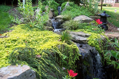 Photo of a mid-sized rustic full sun backyard stone water fountain landscape in Other for spring.
