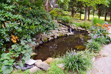 Inspiration for a large modern backyard stone water fountain landscape in New York.
