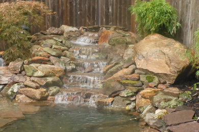 This is an example of a mid-sized modern backyard stone landscaping in Newark.