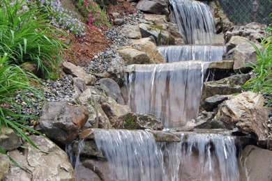 This is an example of a mid-sized asian backyard water fountain landscape in New York.