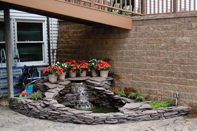 Design ideas for a transitional backyard stone water fountain landscape in Cleveland.