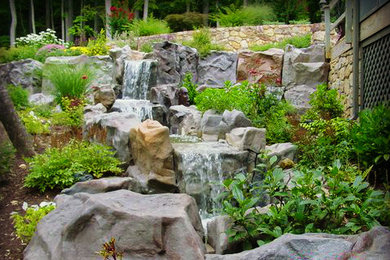 Design ideas for a mid-sized rustic full sun backyard stone landscaping in Other.