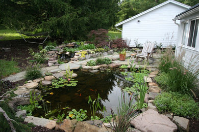 Photo of a mid-sized traditional full sun backyard stone landscaping in Boston for spring.