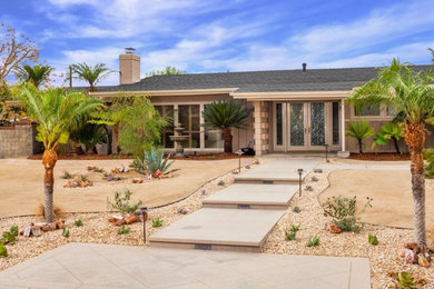 Modelo de jardín de secano de estilo americano grande en patio delantero con exposición total al sol, adoquines de hormigón y paisajismo estilo desértico