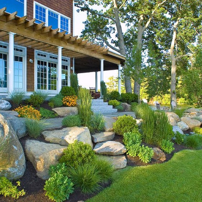 Design ideas for a large traditional partial sun hillside stone landscaping in Boston for summer.