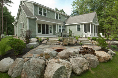 Design ideas for a mid-sized traditional backyard stone landscaping in Portland Maine with a fire pit for fall.