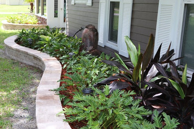 Design ideas for a mid-sized coastal partial sun front yard concrete paver retaining wall landscape in Orlando.